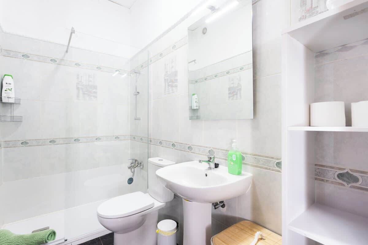 A bathroom with a toilet, sink, and shower.