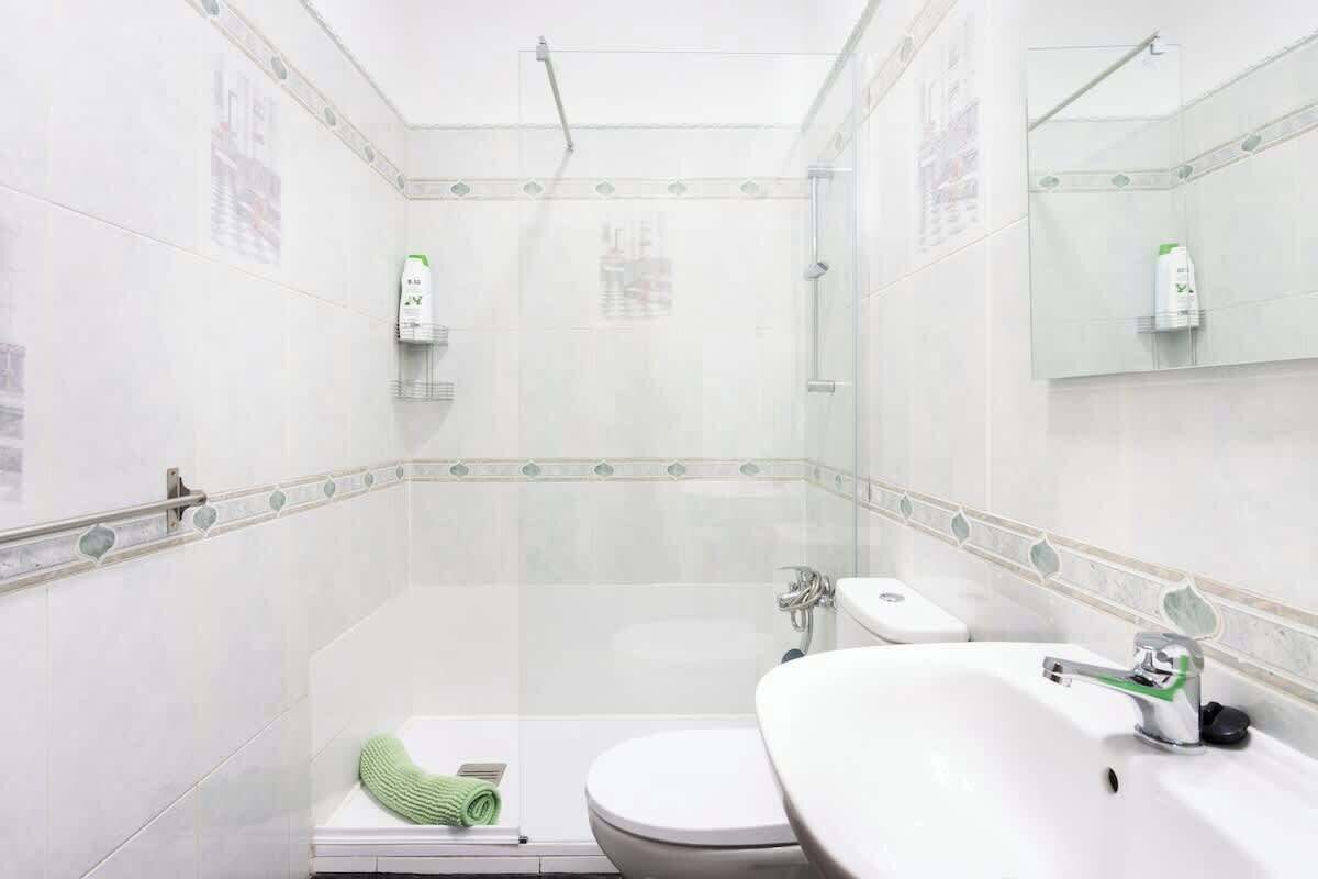 A bathroom with a toilet, sink, and shower.