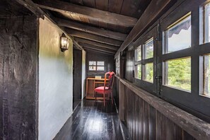 A narrow hallway with wooden walls and a wooden desk with a chair.