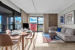A modern living room with a dining area, large windows, and artwork on the walls. - Górczewska Apt - Balcony, Parking, A/C - by Rentujemy (Warszawa)