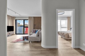 A modern living room with a sofa, a coffee table, a TV, and a balcony with curtains. - Górczewska Apt - Balcony, Parking, A/C - by Rentujemy (Warszawa)