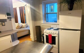 Una cocina compacta equipada con estufa, horno y refrigerador.