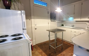 Una cocina con estufa, pileta y encimera.