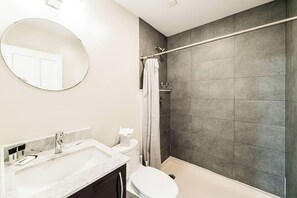 Ein Badezimmer mit Badewanne, Toilette, Waschbecken, Duschvorhang und Spiegel.