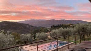 Zona de piscina con vistas a montañas y árboles.