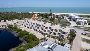Un hôtel situé sur la côte, composé de plusieurs bâtiments, doté d’une piscine et offrant une vue sur la plage et l’océan.