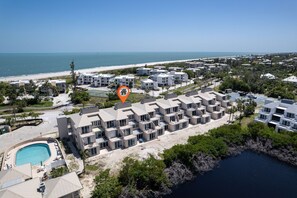 Ein Hotel an der Küste mit mehreren Gebäuden, einem Pool und Blick auf den Strand.