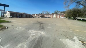 A large parking lot with multiple buildings, including a motel with a signboard.