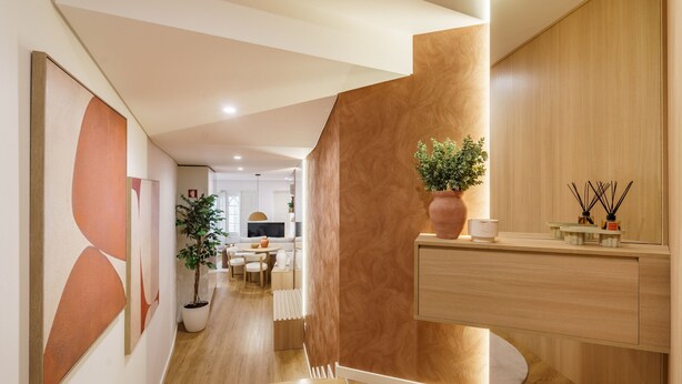 A modern interior with a wooden reception desk, a potted plant, and a minimalist design. - Casa do Livro - E a de Queir s Apartment by Minho (Guimarães)