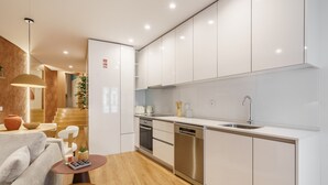 A modern kitchen with white cabinets, stainless steel appliances, and a wooden floor. - Casa do Livro - E a de Queir s Apartment by Minho (Guimarães)