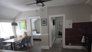 A modern hotel room with a dining area, a kitchen, and a living space.