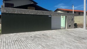 En boligejendom med en belagt indkørsel, en garageport og en stenvæg.