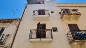 A multi-story building with balconies, a central entrance, and a clear sky. - Guest House Ortigia Calarossa (Syracuse)