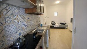 A kitchen with patterned tiles, a stove, and a sink. - Guest House Ortigia Calarossa (Syracuse)