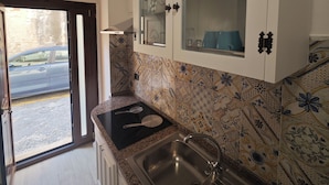 A kitchen with a granite countertop, stainless steel sink, and patterned backsplash. - Guest House Ortigia Calarossa (Syracuse)