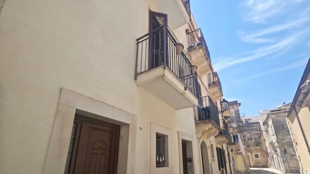 A narrow street with buildings on either side, featuring balconies and doors. - Guest House Ortigia Calarossa (Syracuse)