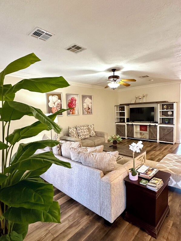 A living room with a sofa, coffee table, and a TV stand.