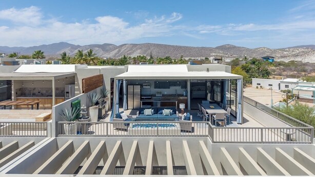 A modern house with a patio, a pool, and a view of mountains. - Modern 4BR Villa with Rooftop & Pickleball (Los Barriles)