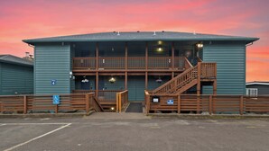 A building with a ramp and a staircase, a sign indicating no parking, and a wheelchair accessibility sign. - Sunset Haven (Depoe Bay)