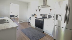 A modern kitchen with stainless steel appliances, a built-in oven, and a microwave. - Relaxing Ranch Home in Eastlake (Atlanta)
