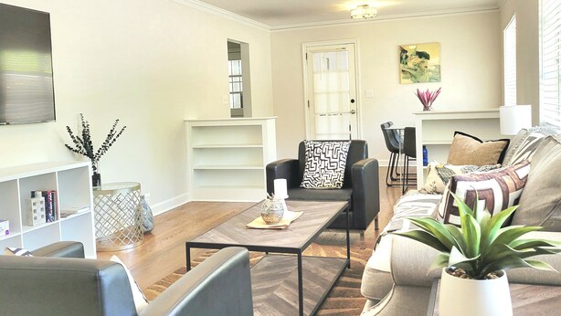 A living room with a sofa, a coffee table, a TV, and a bookshelf. - Relaxing Ranch Home in Eastlake (Atlanta)