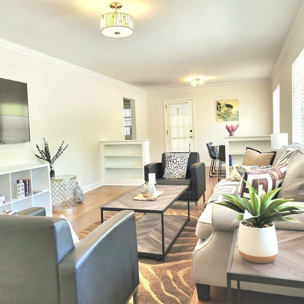 Ein Wohnzimmer mit Sofa, Couchtisch, Fernseher und Bücherregal.