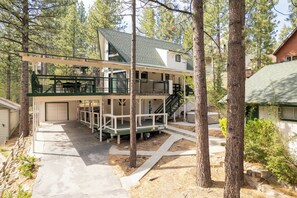 Ein zweistöckiges Haus mit überdachter Veranda, einer Garage und einer Treppe, die zum oberen Stock führt.