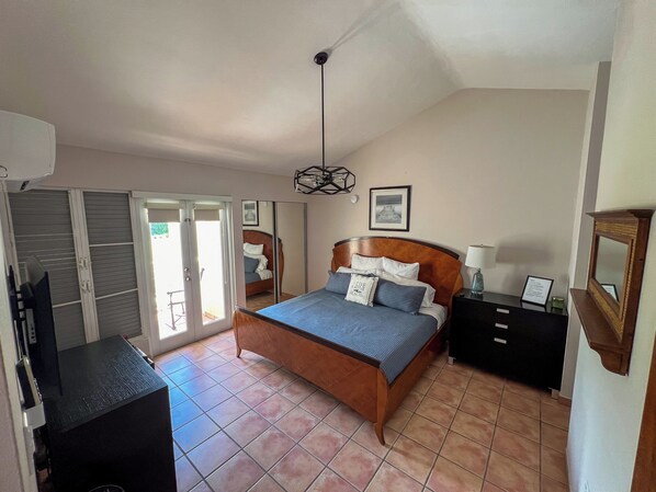 A bedroom with a bed, a desk, a chair, a wardrobe, and a door leading to a balcony. - Villa Merchán (Dorado)