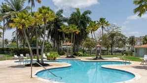 A swimming pool with palm trees, lounge chairs, and a gazebo. - Villa Merchán (Dorado)