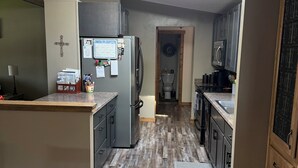 Una cucina con frigorifero, microonde e mobili in legno.