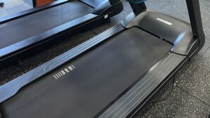 Un gimnasio con cintas de correr y equipo de ejercicio.