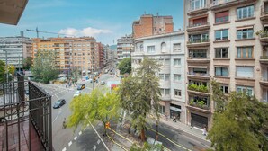 A multi-story building with balconies, a street view, and a clear sky. - Two bedroom apartment Uptown Barcelona (Barcelona)
