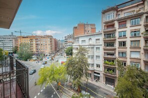 A multi-story building with balconies, a street view, and a clear sky. - Two bedroom apartment Uptown Barcelona (Barcelona)