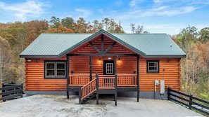 A log cabin with a porch, a staircase, and a metal roof. - Luxury Cabin, Sleeps 22 w/ Pool, Game Room, Movie Theater! (Sevierville)