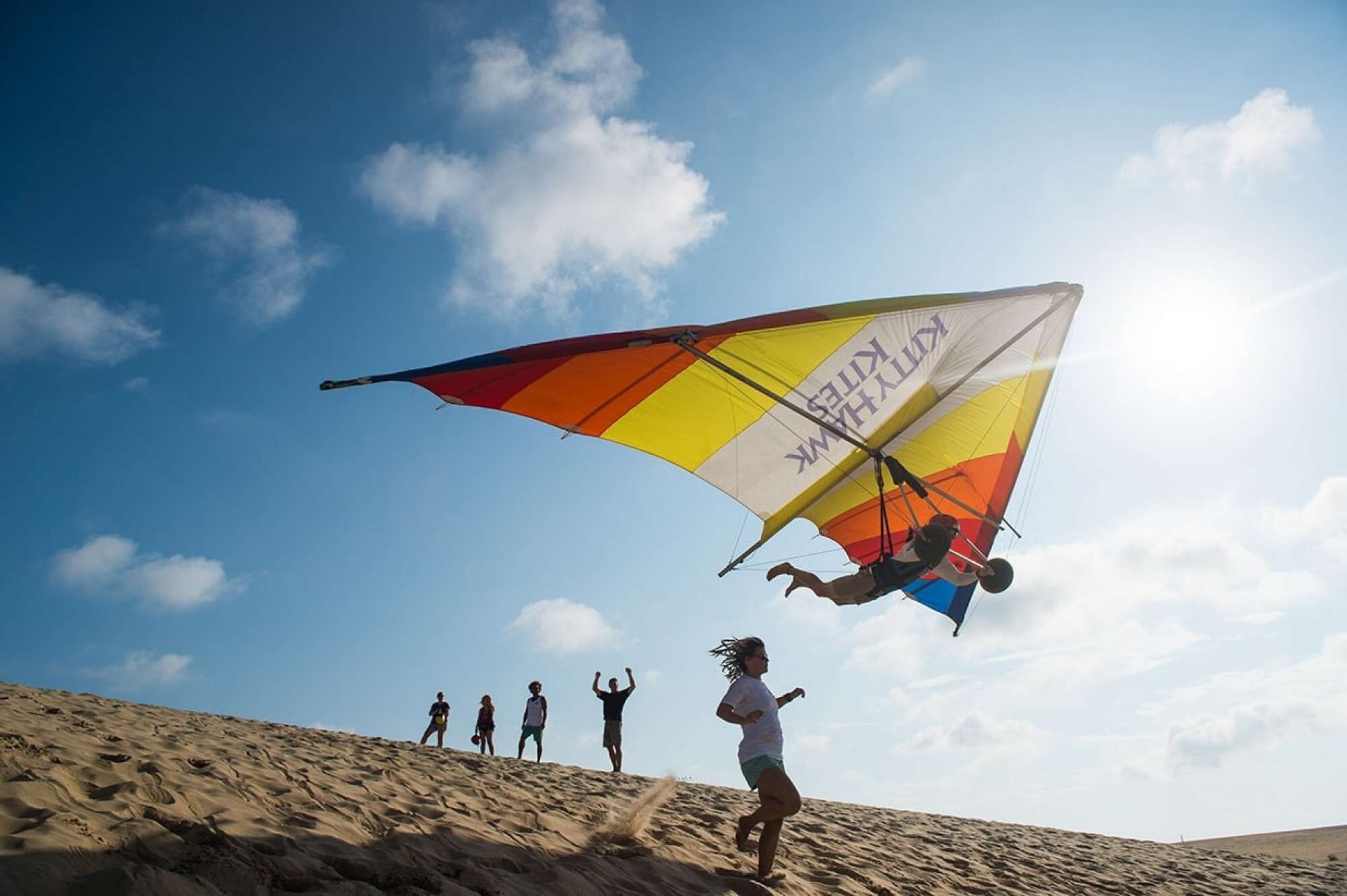 A person in a desert landscape with a colorful kite.