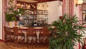 A bar area with a high bar counter, multiple hanging lights, and a variety of bottles and glasses on shelves. - King Suite on the Outer Banks + Restaurants & Spa (Duck)