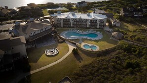 A resort with a large pool, multiple buildings, and a view of the water. - King Suite on the Outer Banks + Restaurants & Spa (Duck)