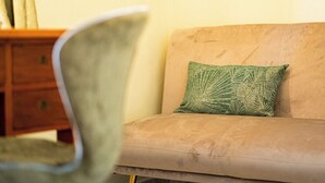 A room with a beige sofa, a green patterned pillow, and a wooden side table. - Seaside villa, suitable for families and friends, only 5 minutes from the Valley of the Temples. (San Leone)