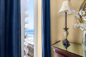 Ein Zimmer mit Blick auf den Strand, einer Lampe und einer Blumenvase.