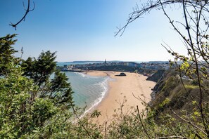 Eine Küstenstadt mit Strand, Gebäuden und blauem Himmel.