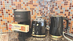Eine Küchenarbeitsplatte mit Kaffeemaschine, Toaster und einer Tasse.