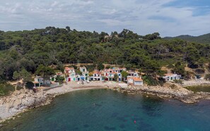 A coastal village with colorful buildings, clear turquoise waters, and a forested hillside. - Solina | Swimming Pool | Terrace | Palamos (Palamos)