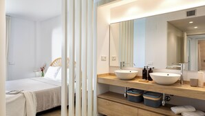 Un baño moderno con dos lavamanos, un espejo grande y un mueble de tocador de madera.