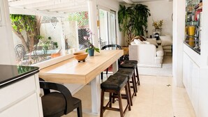 Une cuisine avec un plan de travail en bois, des chaises noires et un canapé blanc.