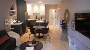 Un appartement moderne comprenant un coin repas, une cuisine et un salon.