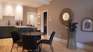 Une cuisine moderne avec des meubles de rangement de couleur sombre, une table de salle à manger ronde et des chaises.
