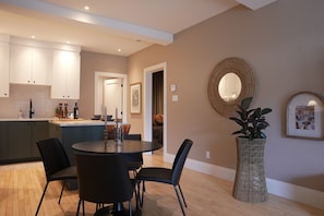 Une cuisine moderne avec des meubles de rangement de couleur sombre, une table de salle à manger ronde et des chaises.