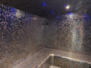 A room with a tiled wall and a curved bench. - Charmant studio à deux pas de Honfleur | Piscine (Gonneville-sur-Honfleur)