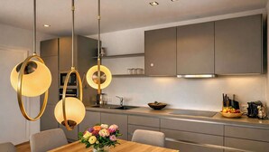 A modern kitchen with pendant lighting, a wooden dining table, and a vase of flowers. - ZILLER DELIGHT – Stylish Apartment with Balcony & Mountain View (Fügen)