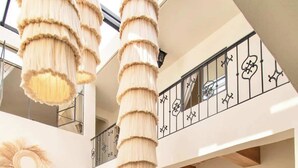 Ein großzügiger Innenraum mit hoher Decke, einem Essbereich mit langem Tisch und einem Balkon mit schmuckvoller Reling.